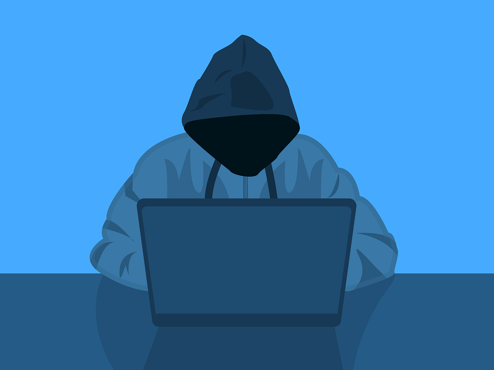 Hacker using a laptop, representing cybersecurity threats to remote workers.